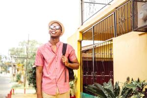 black young adult tourist go with eyeglasses holding a backpack photo
