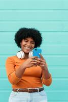 Beautiful Afro woman using mobile on the street. technology concept. photo