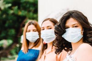 latinx friends using face mask, corona virus concept. photo