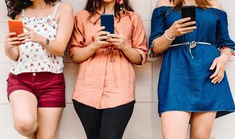 Unrecognizable group friends using smart phones photo