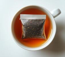 Brewing a warm cup of tea with a steeping bag in a cozy ceramic mug at home photo