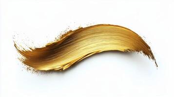 Golden paint stroke on a white background demonstrating texture and artistic expression photo