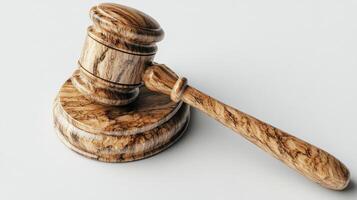 A classic wooden gavel resting on a clean white surface illuminated by soft light photo