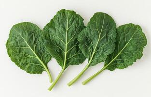Fresh green collard greens arranged neatly on a white background ready for cooking or salads photo