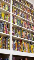 Bookshelf in library with many books. Shallow dof. video