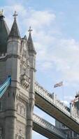 Close-up of ancient architecture of bridge with towers. Action. Beautiful medieval figure of famous bridge towers in UK on blue sky background video
