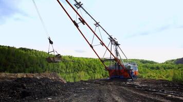 Heavy Machinery Engaged in Mining Operations Set Against a Lush Green Backdrop of Nature. Stock Clip video