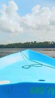 Fishing boat in the river, first person view. Action. Old boat floating along green shore and blue cloudy sky on the background. video