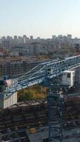 Top view of city with modern buildings and construction. Stock footage. Construction site of building with cranes in center of modern city. Construction of stadium in center on horizon with city on video