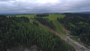 Top view of landslide on hillside. Clip. Mudslide near slope of old village in summer. Landslide on edge of village in valley with green forest and slope video