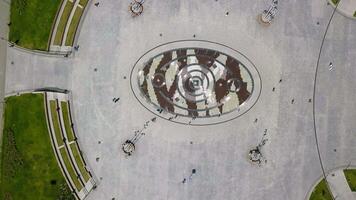 Top view of city square with fountain in summer. Clip. Modern design of fountain in center of square in busy city. Modern square with people and fountain on summer day video