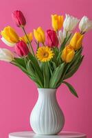 Colorful tulips and daisies arranged in a white vase against a pink background in springtime photo