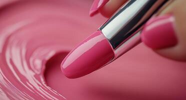 Bright pink nail polish application with a brush in a beauty studio photo