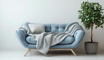 Cozy blue sectional sofa with decorative pillows and a soft throw blanket next to a green plant photo