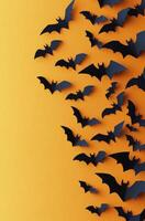 A collection of paper bats flying against a bright orange background during autumn season photo