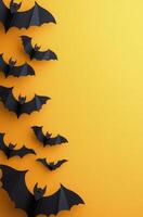 A collection of paper bats flying against a bright orange background during autumn season photo