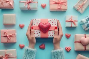 Hands with a wrapped gift among colorful presents and heart decor on a blue background photo