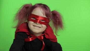 Funny child girl in costume and mask plays super hero. National superhero day video