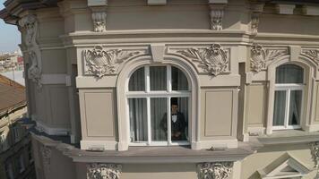 Aerial view of stylish groom man stay at window at home gets ready before date or meeting with bride video