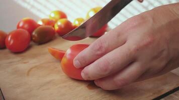 men's hands cutting fresh tomatoes into pieces in the kitchen video