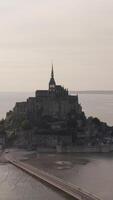 Aerial view of the famous French landmark Mont-Saint-Michel located on the small island near the riverside. Action. Amazing view of old gothic architecture video