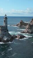 Top view of rocky cape landscape and lighthouse in sea. Clip. Fabulous landscape of rocky cape of island with abandoned lighthouse. Seascape with rocky cape and lighthouse on sunny day video