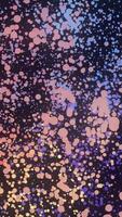 Many round colorful particles in space moving in a circle on black background, seamless loop. Animation. Small chaotic dots of red, yellow, purple colors flying in the dark. video