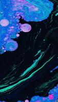 Bright fluid art with acidic colors and bubbles. Stock footage. Liquid mixing patterns of bright colors with bubbles on flat surface. Acidic colorful patterns video