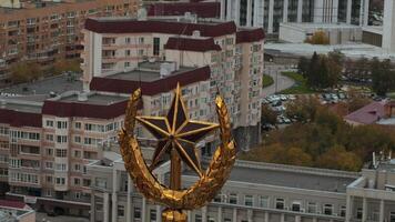 Top view of peak with star on background of city. Stock footage. Golden star at peak of building with panorama of city. Golden star on peak on background of city on cloudy day video