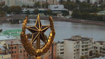 Top view of peak with star on background of city. Stock footage. Golden star at peak of building with panorama of city. Golden star on peak on background of city on cloudy day video