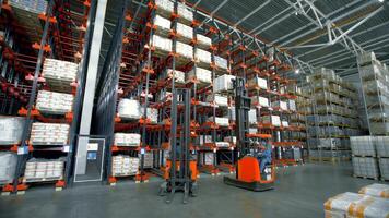 Poland, Warsaw- September 14, 2022. Stacker distributes boxes in warehouse. Creative. Stacker pulls boxes from high shelves in warehouse. Forklift truck rises to high shelves behind goods video