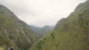 Aerial view of rocks on a summer day on a cloudy sky background. Action. Green forested mountains. video