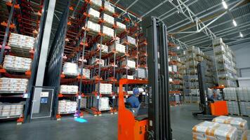 Poland, Warsaw- September 14, 2022. Stacker distributes boxes in warehouse. Creative. Stacker pulls boxes from high shelves in warehouse. Forklift truck rises to high shelves behind goods video