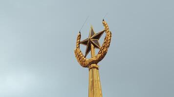 Soviet symbol, golden spire on a cloudy sky background. Stock footage. Golden star and ears of wheat. video