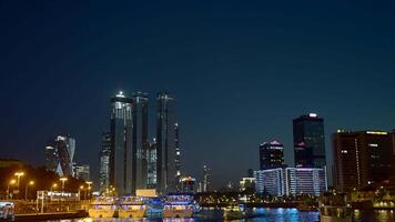 View from the river on the night city with skyscrapers and many lights. Action. Ships and yachts flowing along the river at night. video
