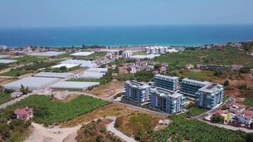 View from a drone flight to the resort area. Clip. View of the sea and the area of hotels and houses with green fields video