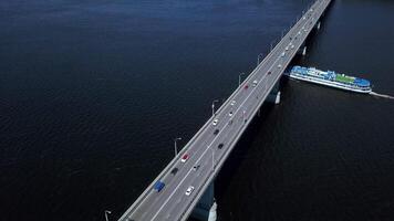 Bird's-eye view. Clip. A huge bridge over the ocean for the movement of cars in different directions and boats and ships passing by are visible. video