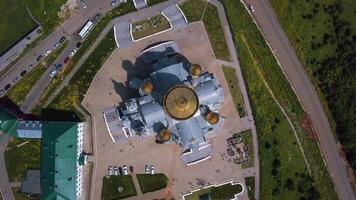 Vertical view of church from above. Clip. Top view of golden domes of church and surrounding area. Flat top view of church in summer video