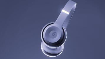 Gray and green background. Design.The concept of new gadgets.Wireless headphones rotate around themselves in animation. video