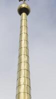 Golden spire of an Orthodox church against the sky. Stock footage. Bottom view of a long shining spire with a cross of a temple or cathedral, religion concept. video