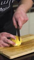 Close up of a male chef cutting a fresh peeled orange on a wooden board. Art. Concept of vegan food, vitamins, and cooking. video