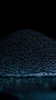 Pile of rocks isolated on black background. Stock footage. Close up of tiny black pieces of gravel lying on a flat reflecting surface, concept of construction materials quality control. video