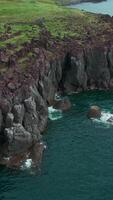 Cliffs and landscape in Iceland, aerial view. Clip. Azure sea and steep stone slope of the shore. video