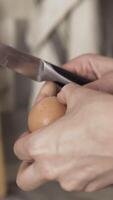 Close up of woman hands breaking the egg with a knife and putting raw white and yolk into the mashed potatoes, cooking concept. Action. Mashed potatoes with eggs in a deep plate in the kitchen. video