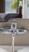 Luxurious bubble bath with clear warm water flowing from the faucet, spa concept. Stock footage. Beautiful light bathroom with big windows prepared for relaxation. video