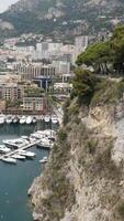 Top view of pier with parked yachts on sea. Action. Beautiful landscape view from rocky coast to seaside town with port for yachts. Expensive yachts moored on coast of resort town video