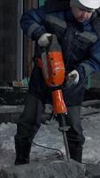 Man drills holes in a concrete block. Clip. Industrial background of a builder at the construction site. video