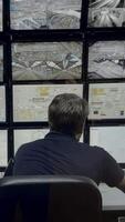 Security officer controls CCTV cameras in office, uses digital tablet and computers. Media. High tech software showing surveillance cameras, concept of social safety. video
