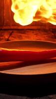 Red hot chili pepper on black background with flame, spicy food concept. Stock footage. Close up of a pepper lying on a wooden board under the hot flame. video