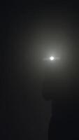Close-up of man's silhouette with flashlight shining in the dark. Stock footage. Silhouette of man in thick fog video